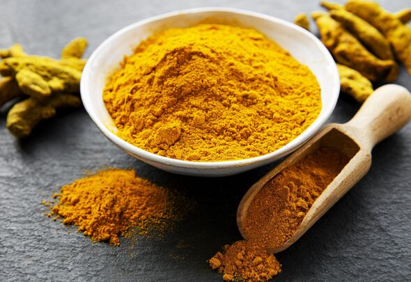 Close-up of ground turmeric in bowl on table,Romania