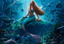 mermaid underwater sitting on a rock