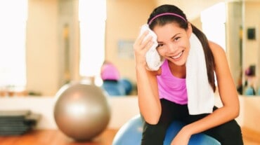 Woman wiping off sweat during workout Woman wiping off sweat during workout